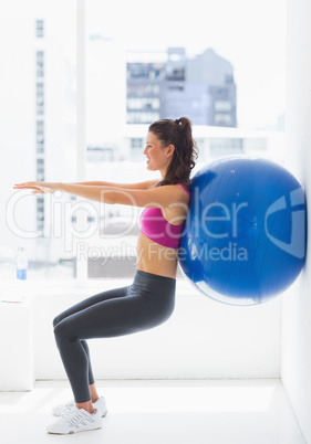 Fit young woman exercising with fitness ball