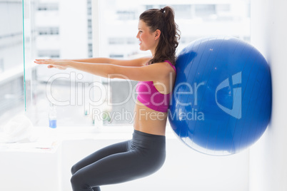 Fit young woman exercising with fitness ball