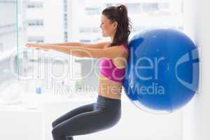 Fit young woman exercising with fitness ball