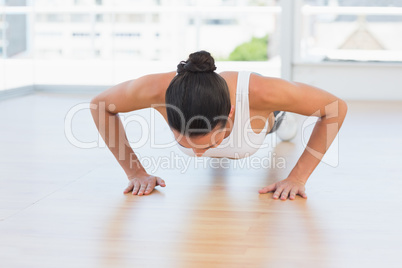 Determined beautiful woman doing push ups in gym