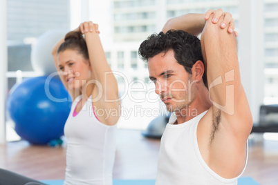 Sporty people stretching hands at yoga class