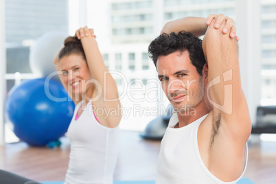 Sporty people stretching hands at yoga class