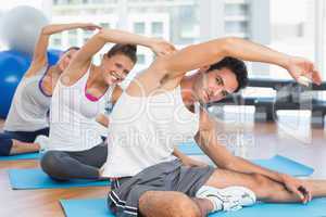 Sporty people stretching hands at yoga class