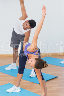 Sporty couple stretching hands at yoga class