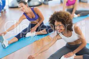 People doing stretching exercises in fitness studio