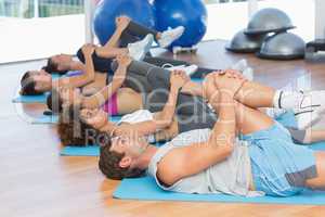 People stretching legs in fitness studio