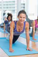 Women doing stretching exercises in fitness studio