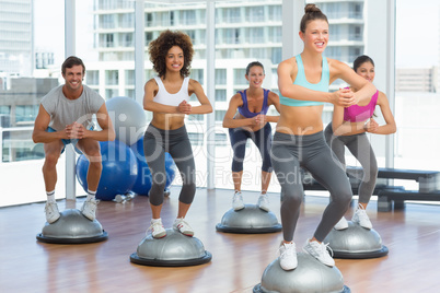 Fitness class and instructor doing pilates exercise