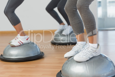 Low section of fit people performing step aerobics exercise