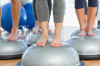 Low section of fit people on exercise equipment