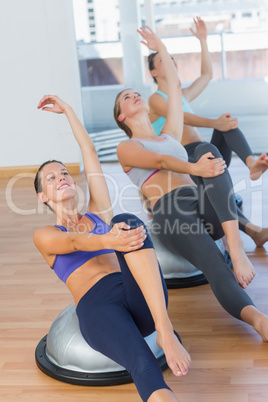 Sporty women stretching hands at yoga class