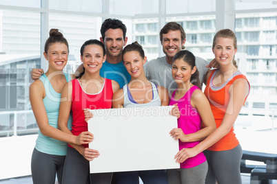 Fit smiling people holding blank board