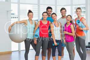 Fit people smiling in a bright exercise room