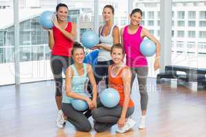 Fit young people with balls in exercise room