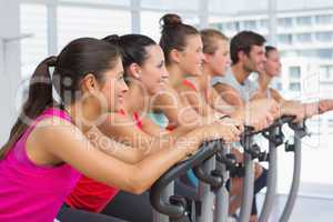 Fit people working out at spinning class