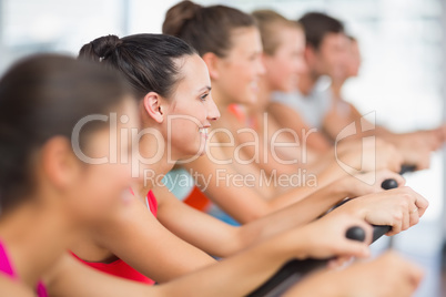 Fit young people working out at spinning class