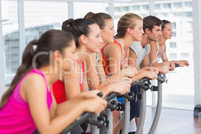 Fit people working out at spinning class