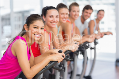 Fit young people working out at spinning class