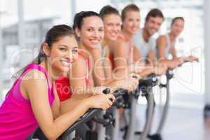 Fit young people working out at spinning class