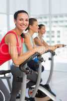 Fit young people working out at spinning class