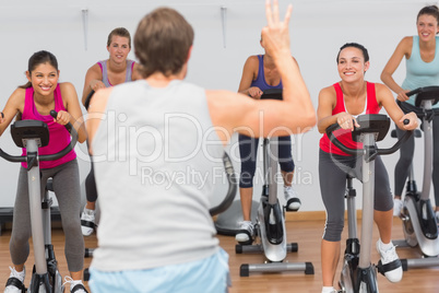 Trainer and fitness class at spinning class