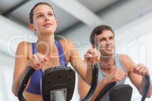 Smiling couple working out at spinning class