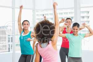 Cheerful fitness class and instructor doing pilates exercise