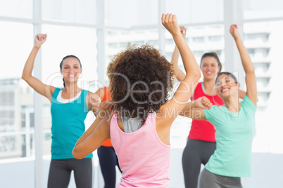 Fitness class and instructor doing pilates exercise