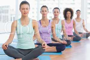 Sporty women in meditation pose with eyes closed