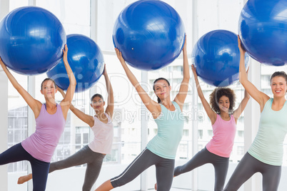 Fitness class doing pilates exercise with fitness balls