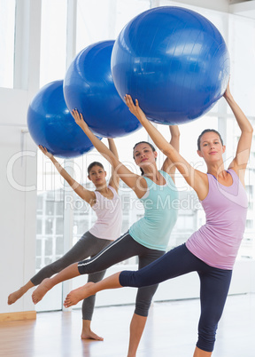 Fitness class doing pilates exercise with fitness balls