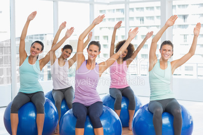 Smiling young people sitting on exercise balls