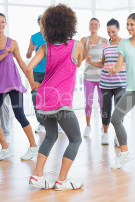 Fitness class and instructor doing pilates exercise