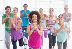 Cheerful fitness class and instructor doing pilates exercise