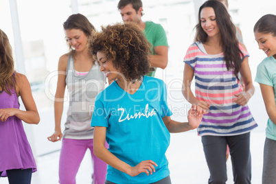 Fitness class doing pilates exercise in bright room