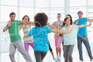 Fitness class and instructor doing pilates exercise