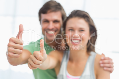 Portrait of a fit young couple gesturing thumbs up