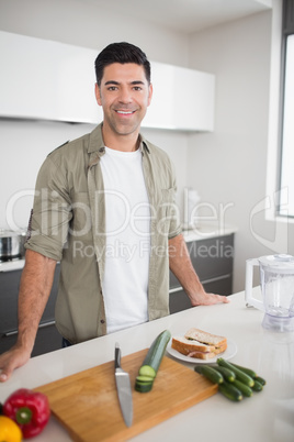 Man with vegetables and chopping board in kitchen