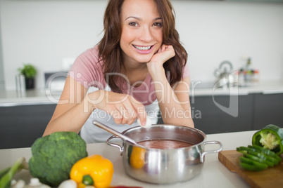 Portrait of smiling woman preparing food in kitchen