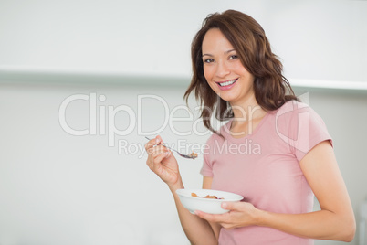 Portrait of smiling woman with a bowl of cereals at home