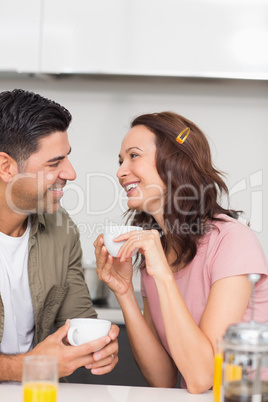 Happy loving couple with coffee cup in kitchen