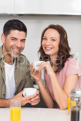 Happy couple with coffee cup in kitchen