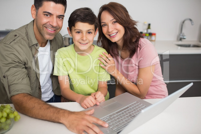 Portrait of a smiling couple with son using laptop