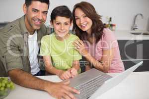 Portrait of a smiling couple with son using laptop