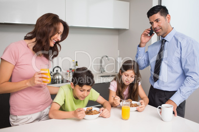 Kids with parents having breakfast in kitchen