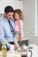 Well dressed father carrying his daughter while preparing food