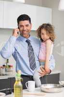 Well dressed father carrying daughter while on call