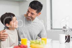 Young son with father having breakfast