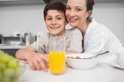 Smiling mother with son at breakfast table in kitchen