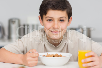 Smiling young boy enjoying breakfast in kitchen